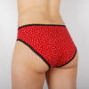 Vue de dos de la culotte menstruelle en coton biologique Biolunes. Culotte rouge avec des pois blancs et des elastiques noirs, fabriquée main en France, Bretagne, Ille et Vilaine, Paimpont